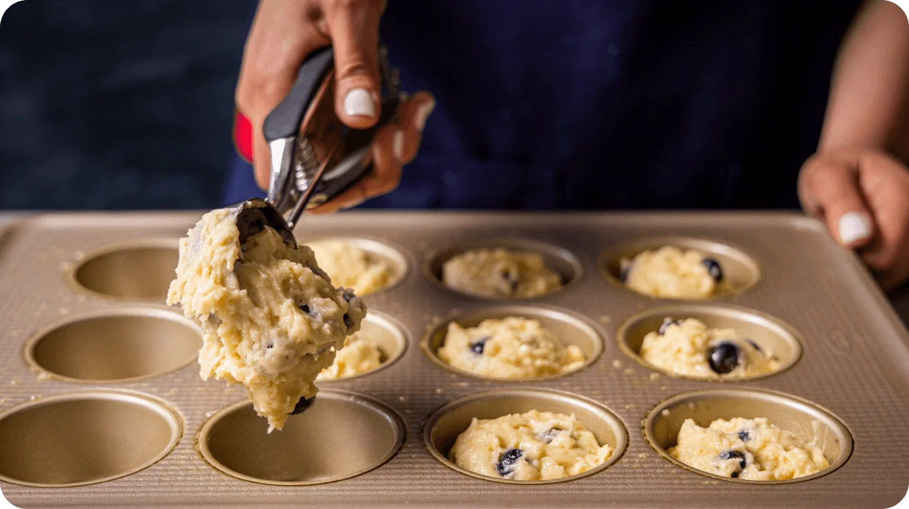 Scooping batter into a muffin tray
