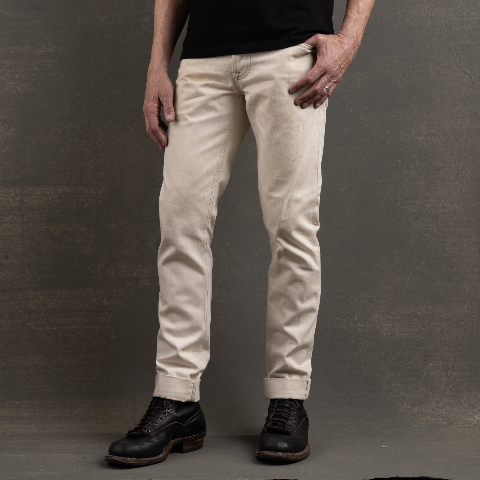 American-made raw denim jeans styled with boots in natural lighting