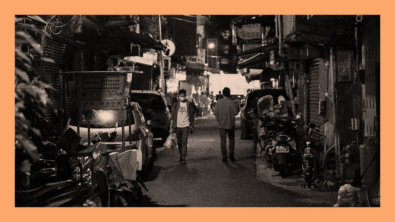 People walking down a street during night time in Taipei