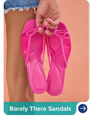 An image of a woman holding a pair of pink sandals. Barely there sandals.