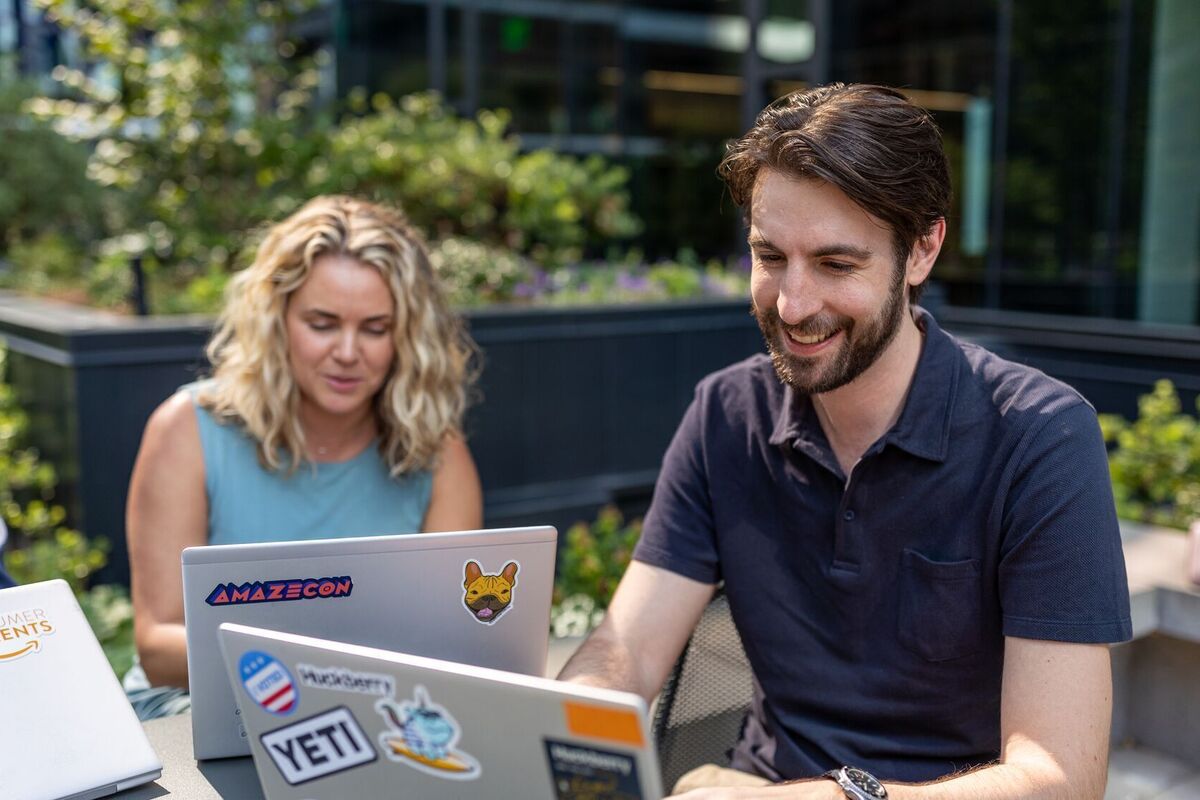 Two people on their computers.
