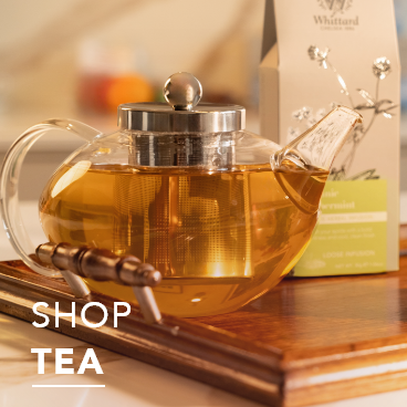 Shop Tea text overlays glass mug of white tea