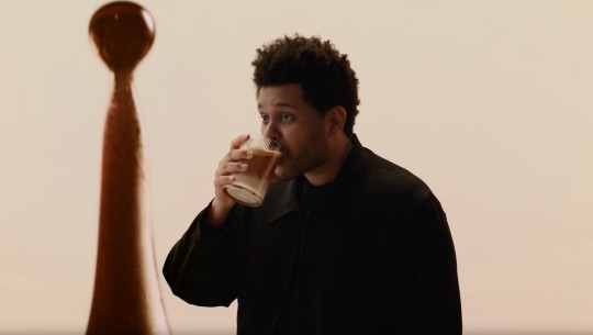 The Weeknd sips from a glass of iced coffee