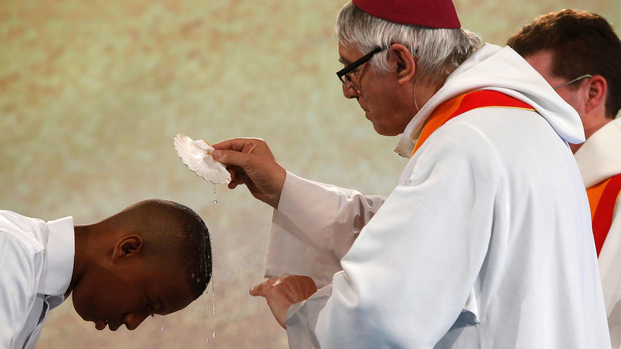 A baptism takes place at a Frat catholic youth camp in France.