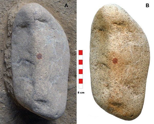 A granite pebble, about 21 cm tall and 8 cm wide, has indents that sort of look like eyes and a mouth, and a fingertip-sized dot in the centre.