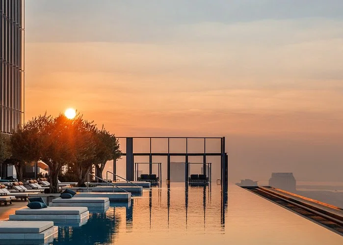 Loungers and rooftop infinity pool at sunset at One&Only One Za'abeel
