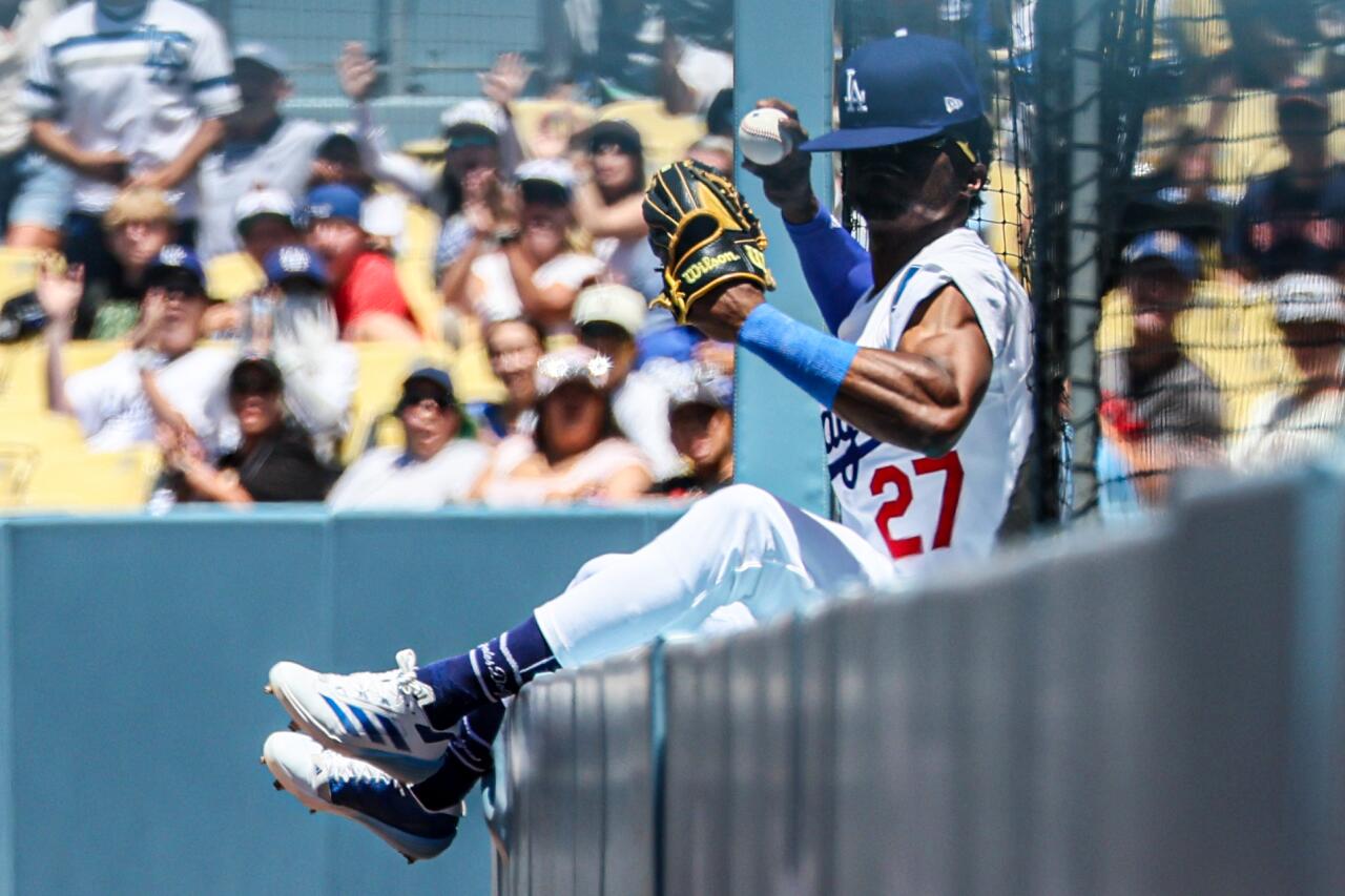 Dodgers right fielder Esteury Ruiz falls into the netting as he catches a third-inning sacrifice fly.