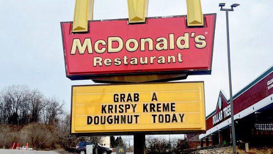 A McDonald's sign reads "Grab a Krispy Kreme Doughnut Today"