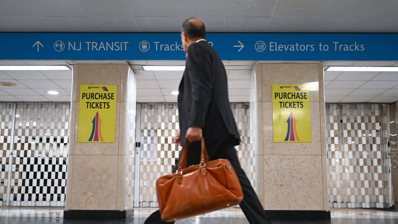 A commuter walks past the closed gates of New Jersey Transit Ticketing area at Penn Station, New York, NY, USA.