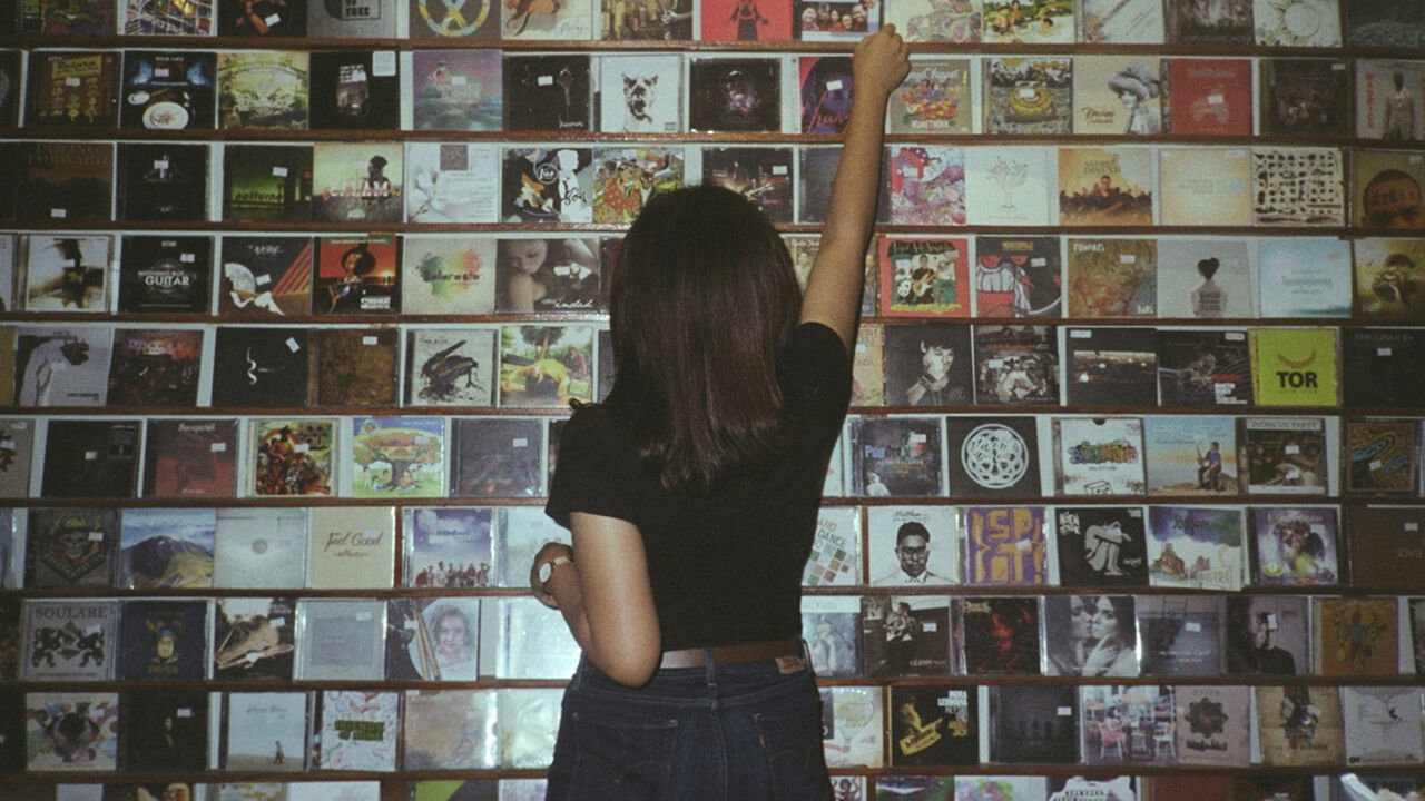 Rear view of a woman choosing a CD in a shop