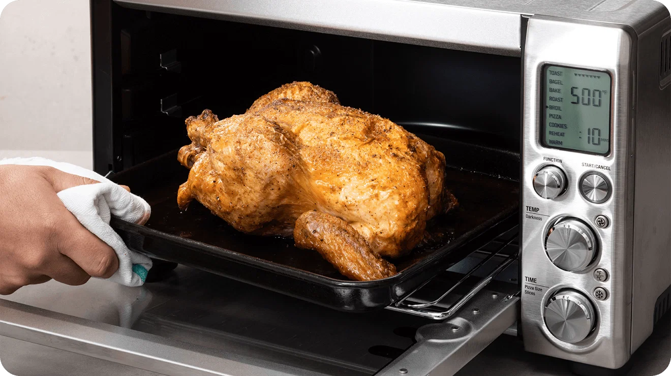 Pulling a whole roasted chicken out of a toaster oven