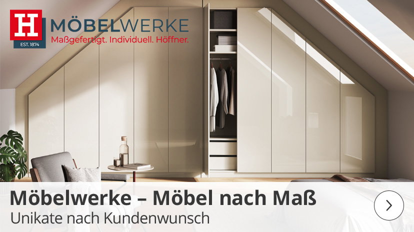 Ein Raum mit einer Dachschräge, in dem maßgefertigte, helle Einbauschränke installiert sind. Ein Teil der Schranktüren ist geöffnet und zeigt eine Kleiderstange und Schubladen. Links im Bild sind ein Sessel und ein kleiner Beistelltisch mit einer Flasche und Gläsern zu sehen. Oben links im Bild befindet sich das "MÖBELWERKE"-Logo mit dem Text "Maßgefertigt. Individuell. Höffner." Eine transparente Leiste am unteren Bildrand zeigt den Text "Möbelwerke – Möbel nach Maß Unikate nach Kundenwunsch".