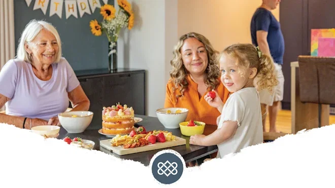 grandmother, mother, and daughter sat in lodge with dad in background