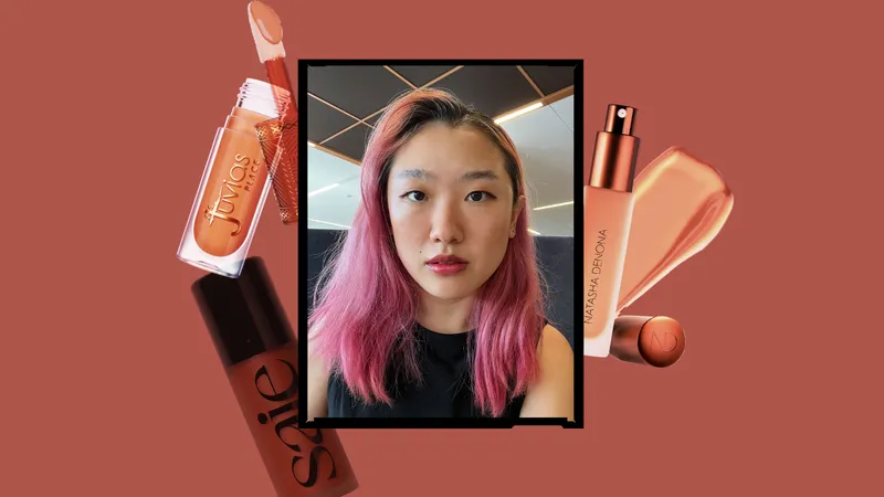 A selfie of Allure commerce editor Sarah Han in a black frame surrounded by liquid bronzers on a brick red background