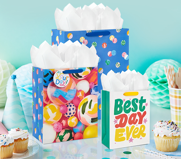 Gift bags with party decorations, party hat and cupcakes.