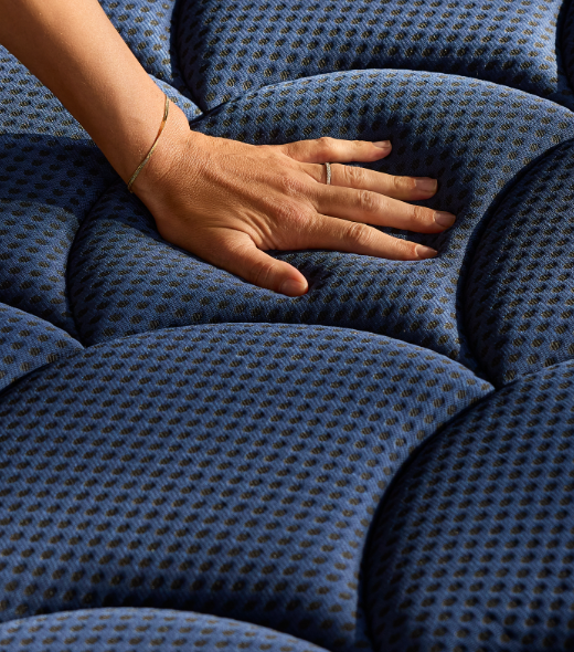 a woman 's hand rests on a blue cushion