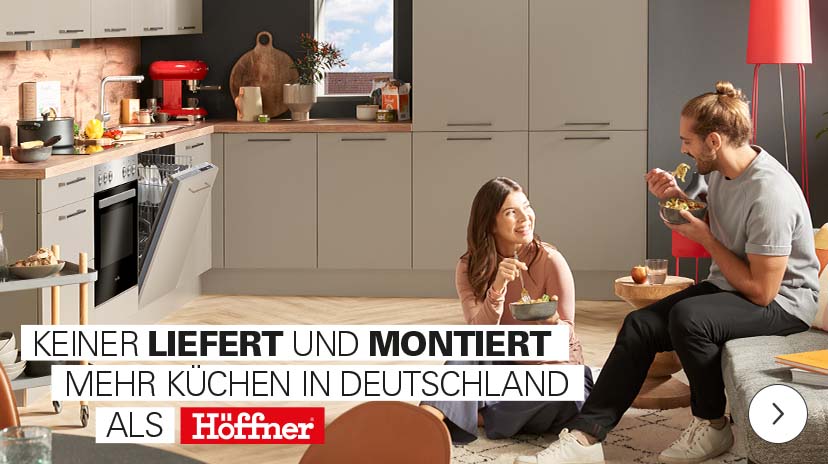 Eine Werbeanzeige für Küchen, die einen lächelnden Mann mit einer Tasse in einer modernen weißen Küche mit goldenen Akzenten zeigt. Die Anzeige bewirbt "1/2 Preis für frei geplante Küchen" und "bis zu 5 Jahre keine Zinsen".