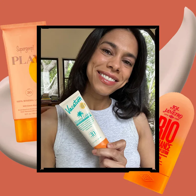A selfie of Allure shopping editor Shanna Shipin holding Vacation Mineral Lotion SPF 30 surrounded by other body sunscreens on an orange background