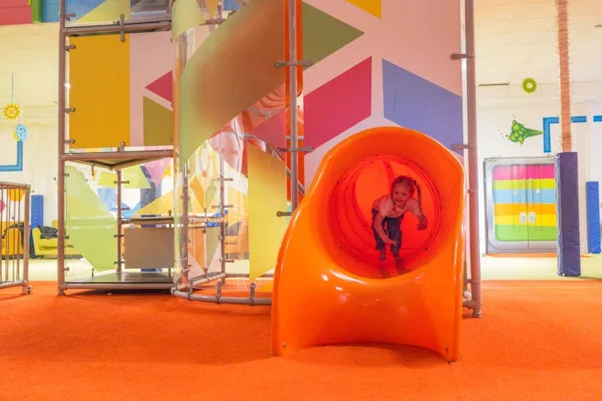 girl coming down slide at the hive