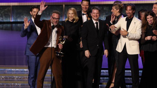 Seth Rogan holds an Emmy on stage with other cast members and producers of 'The Studio'