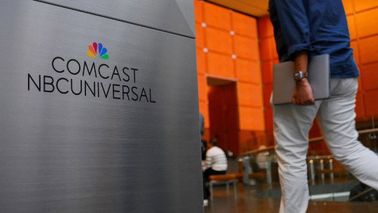 An office lobby sign reads Comcast NBCUniversal beneath the NBC peacock logo