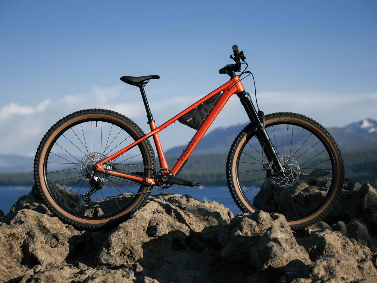 All-new Roscoe hardtail mountain bike on large rocks with body of water and mountains in background