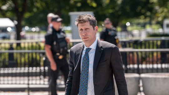 Sam Altman outside in a suit and tie