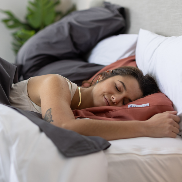 A woman sleeps happily in her bed