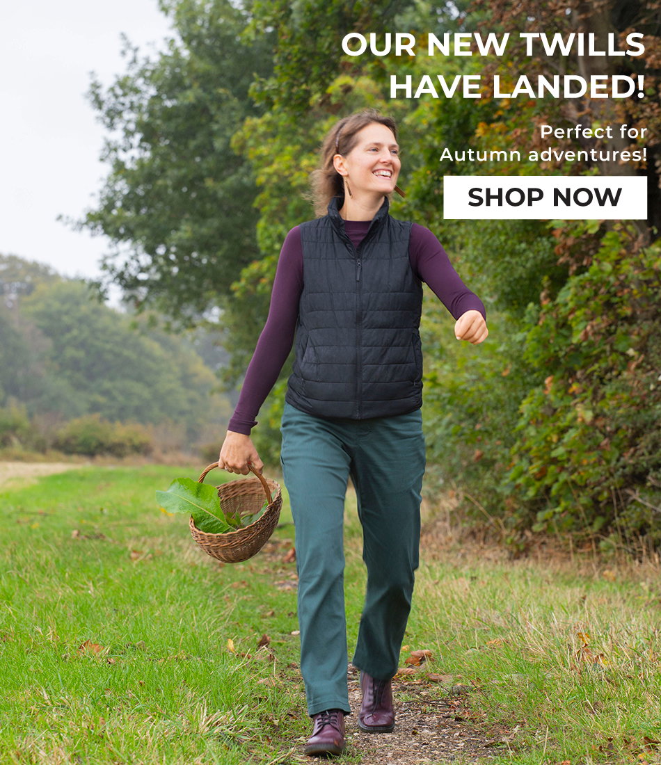 Accessible description: A photo showing Jess wearing the new Johnson trouser in Nori as she walks through a grassy scene carrying a foraging basket. Overlay text reads "Our new twills have landed! Perfect for autumn crag days. Shop now"