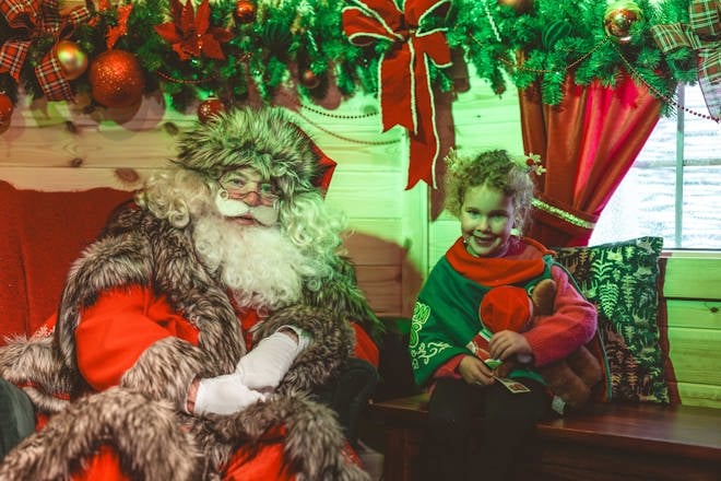 girl with Santa in his lodge