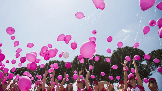 Pink helium balloons rise into the air