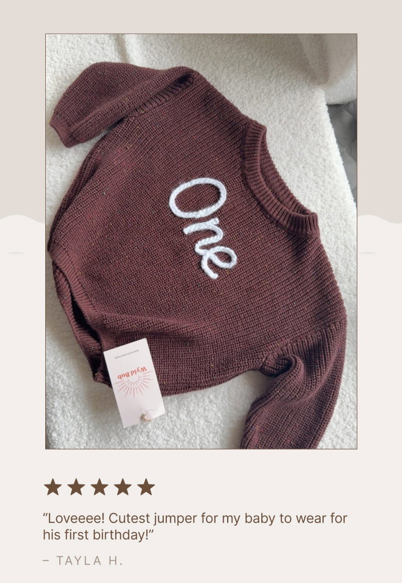 Flat-lay image of a folded rust-colored personalized jumper with the name “Rae” embroidered in white yarn, beside a soft label tag and a five-star customer review from Tayla H.