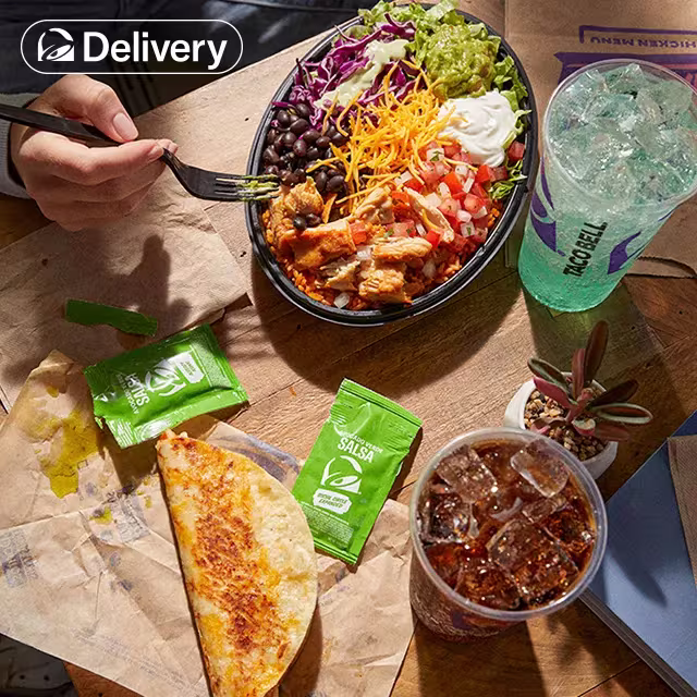 Top down shot of a person sitting atb a table with various Cantina Chicken Menu items and two fountain drinks in front of them.