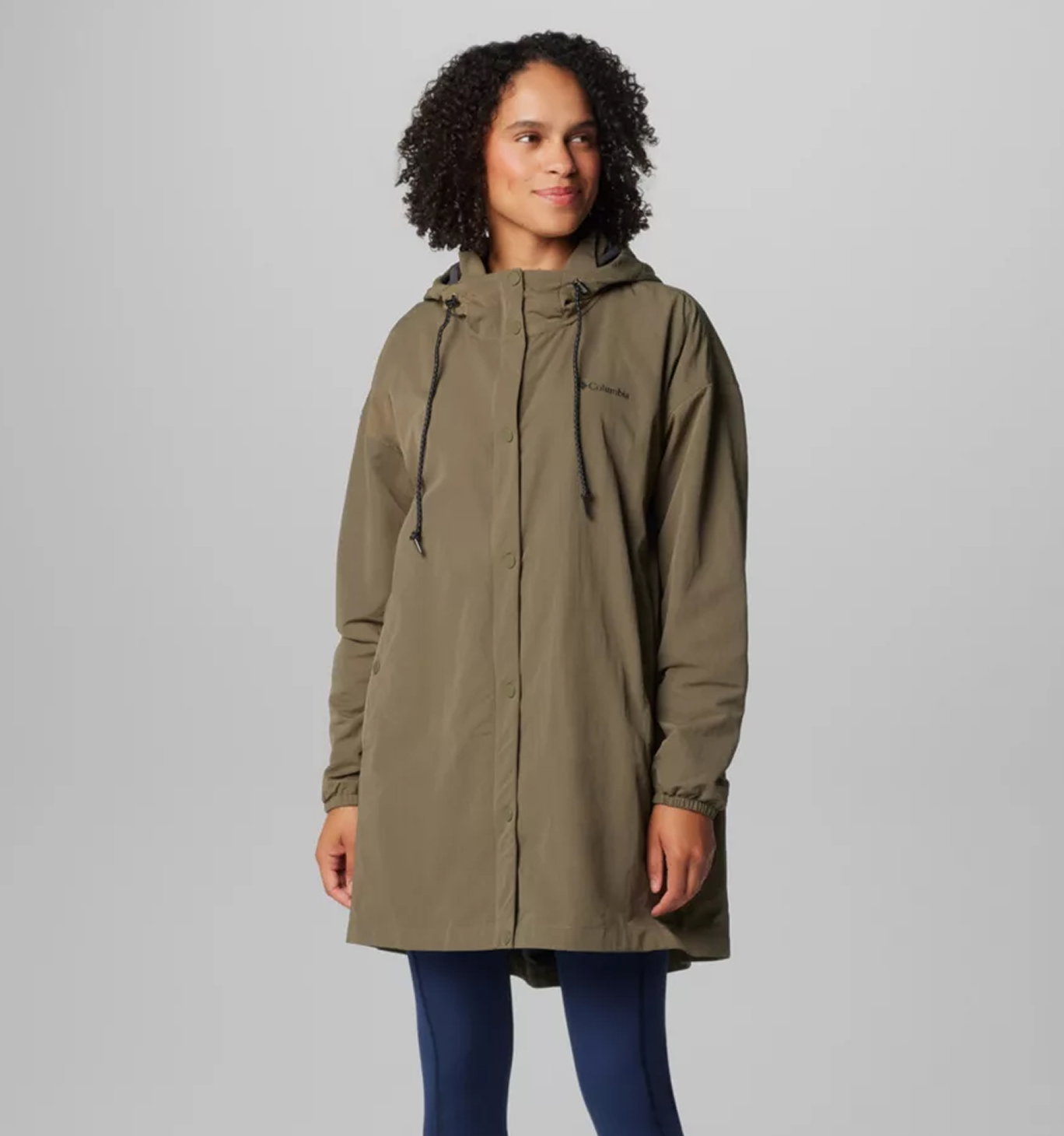 A woman wearing a long olive jacket.