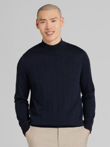 Man wearing navy mock-neck merino sweater.