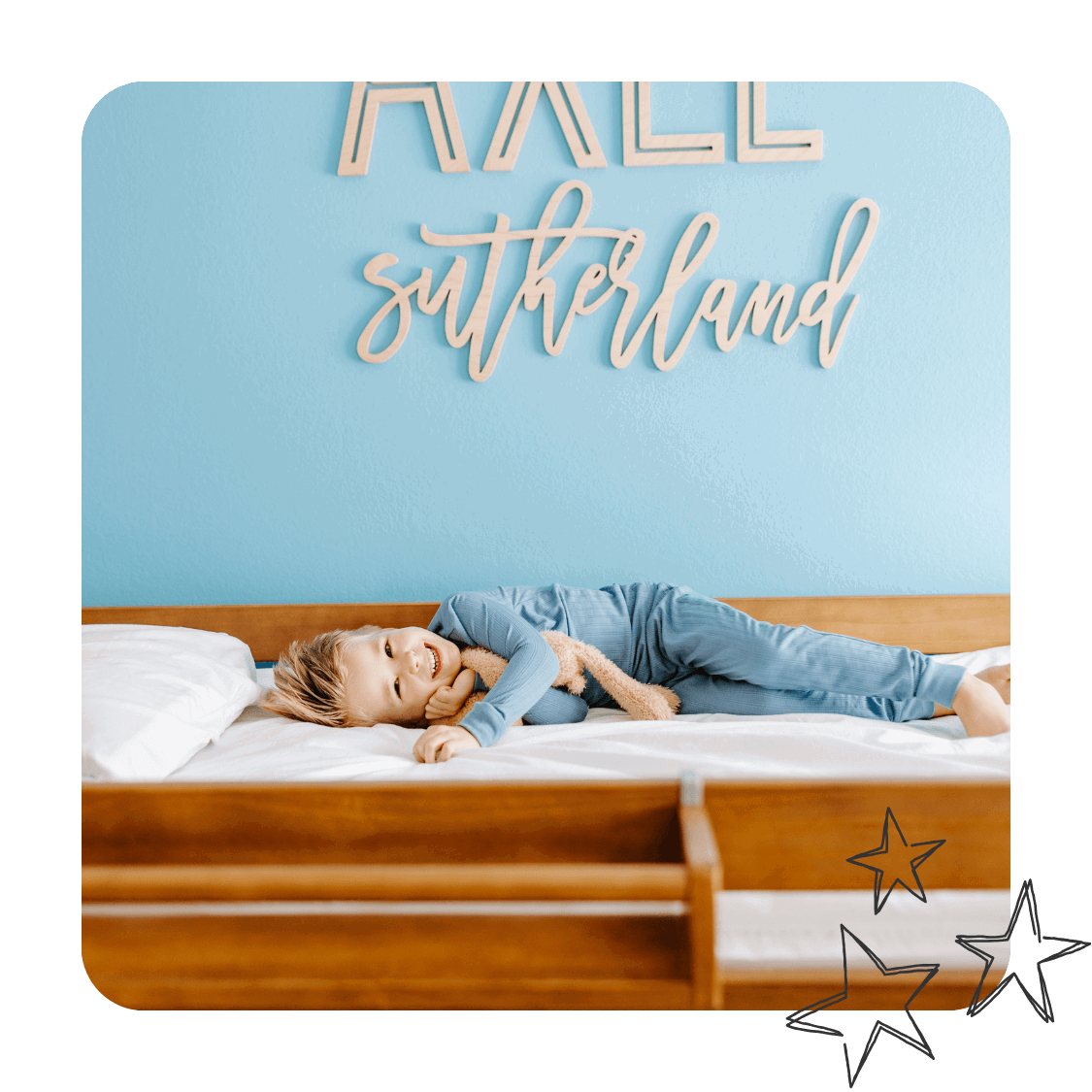 A boy in blue pjs lays in his bunk bed