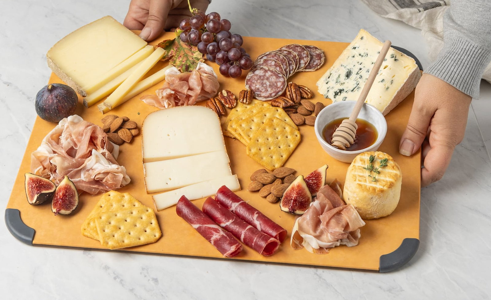 Cutting board with citrus fruits and lemonade in the background.
