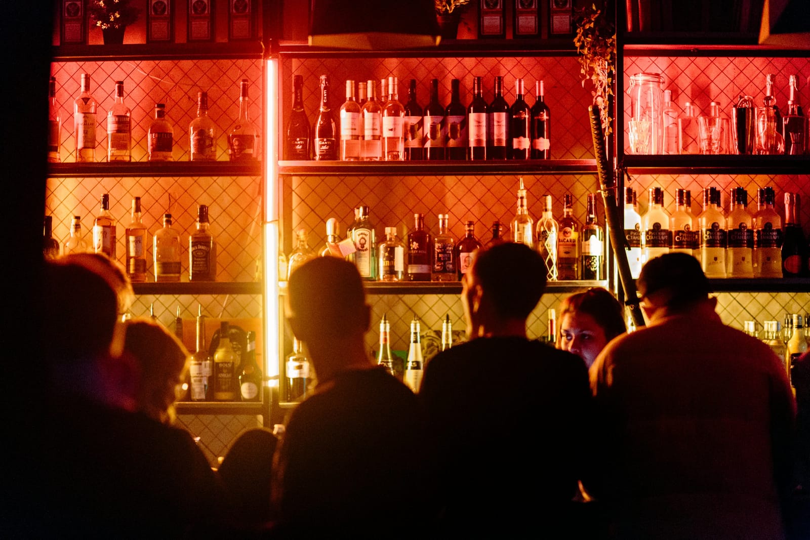 Patrons gather around a bar to order drinks.