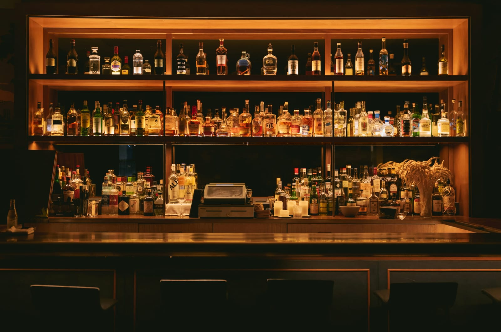 Low-light bar with many bottles on display.