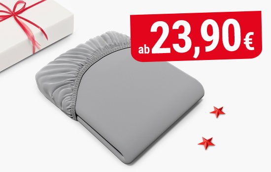 Das zusammengefaltete BODYGUARD Spannbettlaken. Daneben ein Geschenk und Konfetti in Sternform.