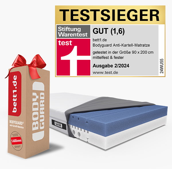 Die BODYGUARD Boxspring Matratze mit geöffnetem Bezug. Daneben ein bett1 Versandkarton mit Schleife. Siegel: Stiftung Warentest