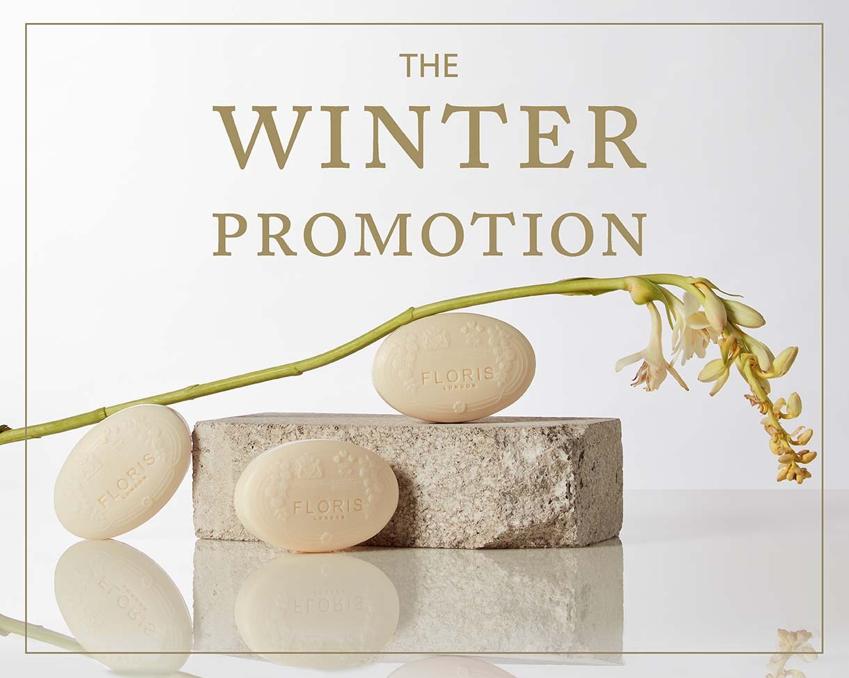 Three bars of Floris soap are displayed on and beside a stone block with an orchid branch, under text that reads "The Winter Promotion.