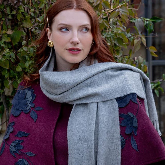 Woman wearing a plain cashmere scarf in dove grey on a walk