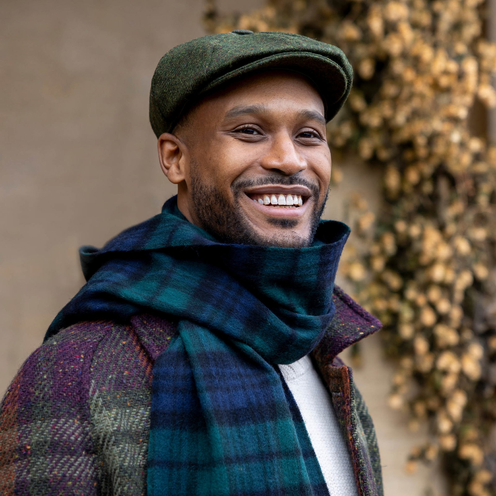 Man wearing tartan cashmere scarf in blackwatch with green flat cap on  walk