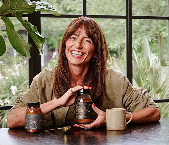 Davina McCall smiling and holding a jar of True Collagen