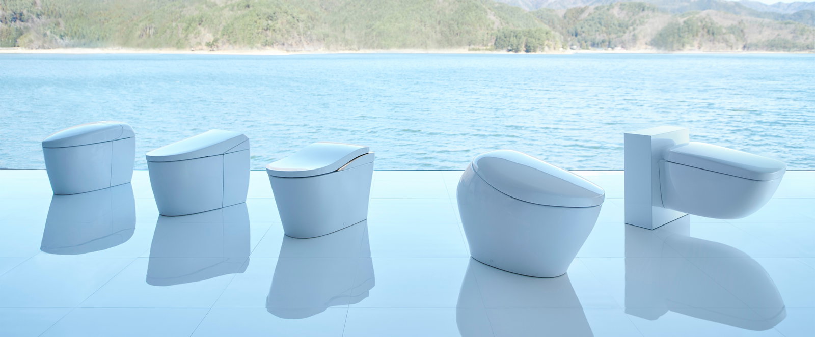 The TOTO NEOREST toilet product line is displayed in front of a scenic blue lake.