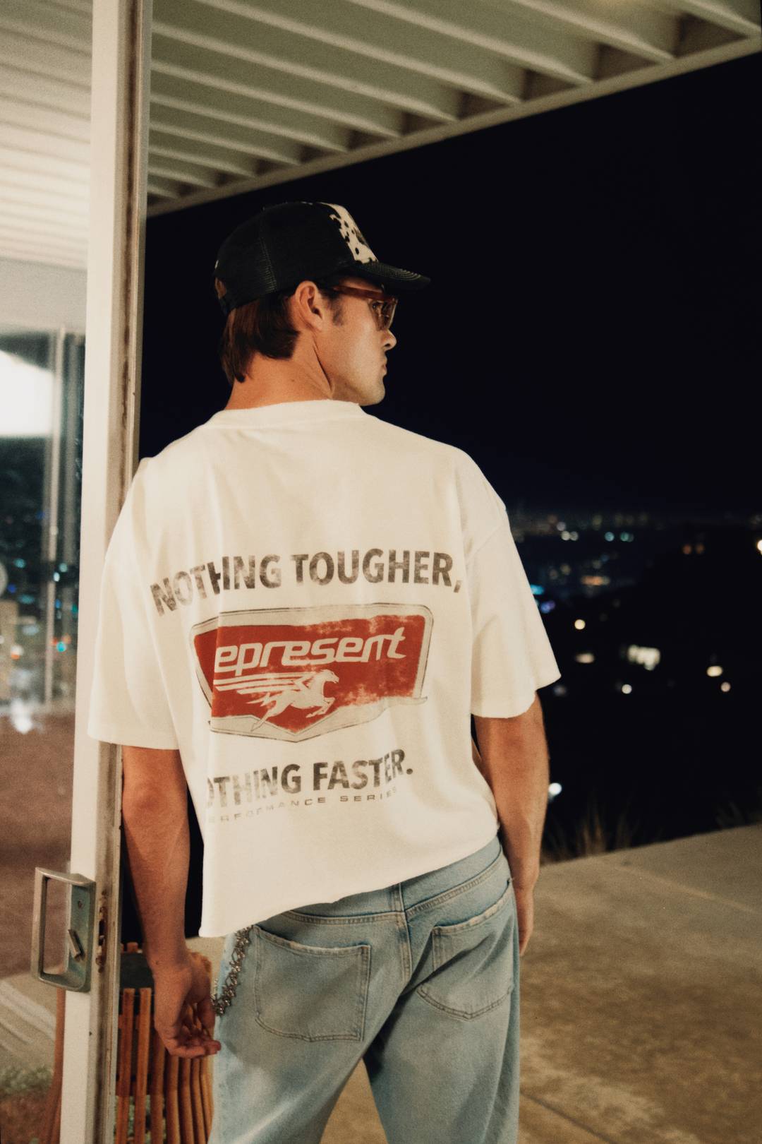 Model wearing the Nothing Faster T-Shirt in Flat White and Cowhide Print Cap