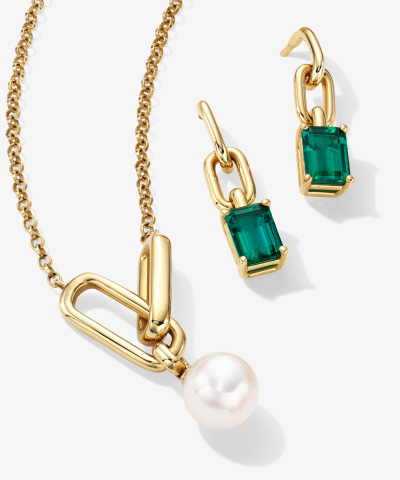 Gold necklace with pearl pendant and matching earrings featuring rectangular green gemstones.