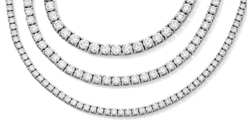 Three diamond tennis necklaces displayed in layered rows.