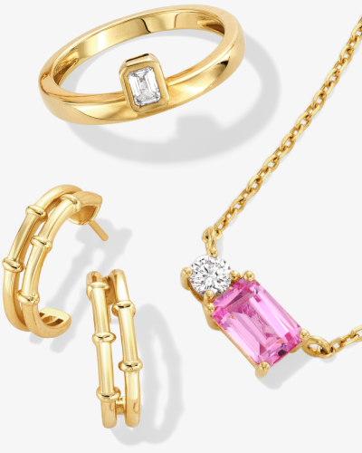 Yellow gold band ring with rectangular stone paired with a pink gemstone pendant necklace and gold hoops.